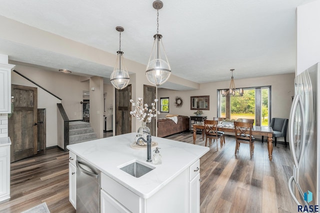 kitchen with pendant lighting, stainless steel appliances, a kitchen island, and white cabinetry