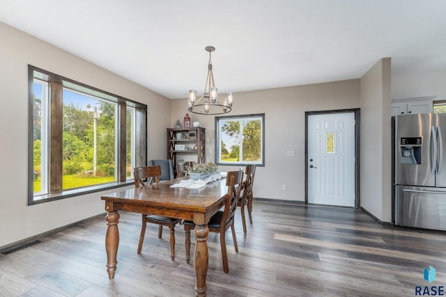 dining space with dark hardwood / wood-style flooring and a chandelier