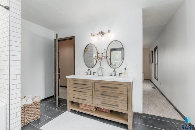 bathroom featuring a textured ceiling, vanity, and tile patterned floors