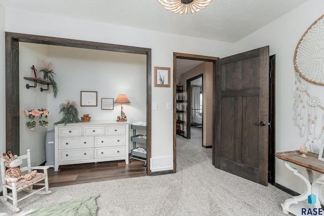 bedroom with a textured ceiling and dark colored carpet