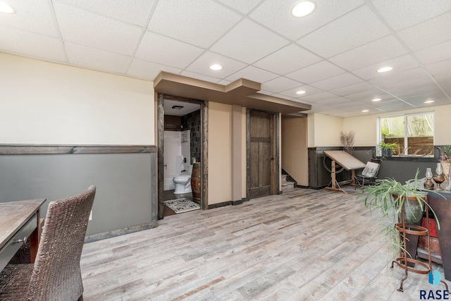 unfurnished office featuring light hardwood / wood-style floors and a drop ceiling