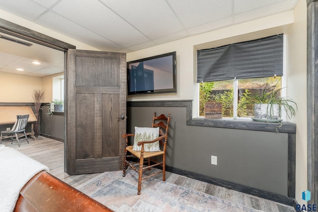 sitting room with a paneled ceiling and light hardwood / wood-style floors