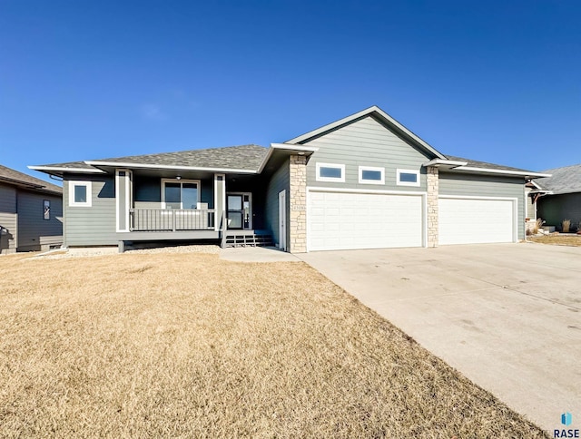 ranch-style house featuring a front yard, a porch, and a garage