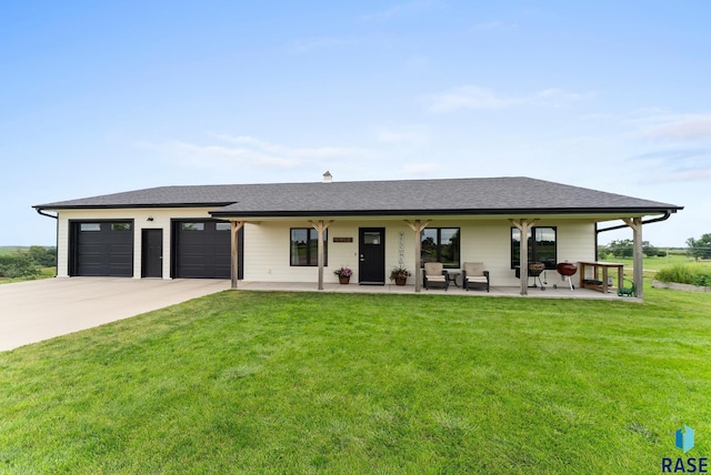 view of front of house featuring a porch, a garage, and a front lawn