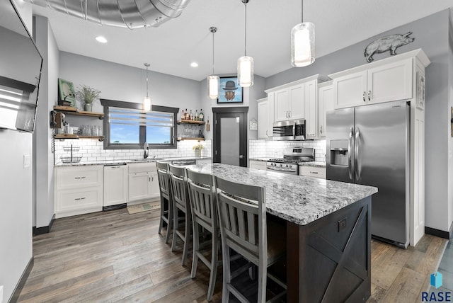 kitchen with white cabinets, a kitchen bar, and stainless steel appliances