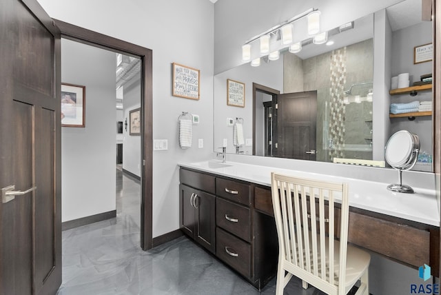 bathroom featuring a tile shower and vanity