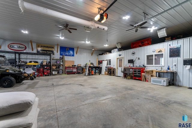 garage featuring a workshop area, a garage door opener, and ceiling fan