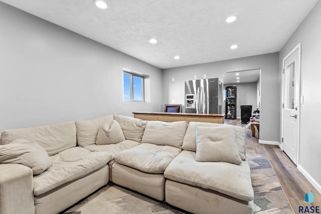 living room with a textured ceiling and hardwood / wood-style flooring