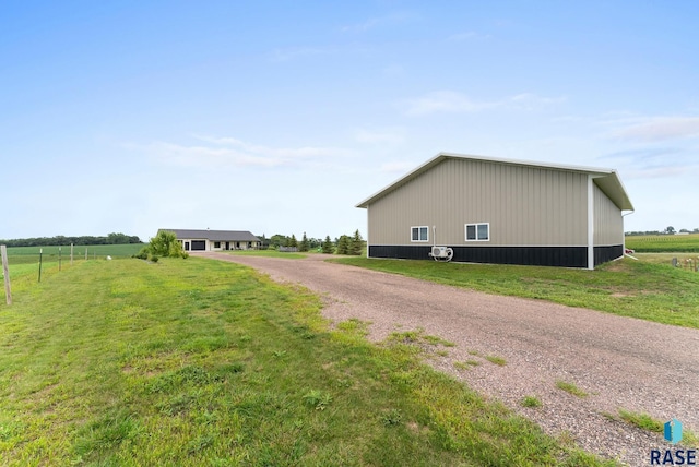 view of property exterior with a yard and a rural view