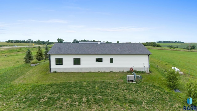 view of property exterior with a yard and a rural view