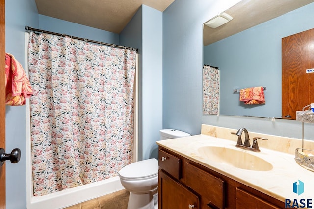 bathroom featuring curtained shower, tile patterned flooring, vanity, and toilet