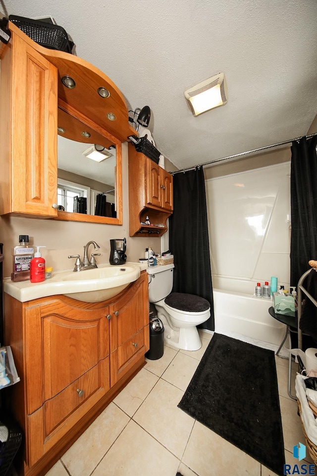 full bathroom featuring vanity, tile patterned floors, shower / bath combination with curtain, toilet, and a textured ceiling