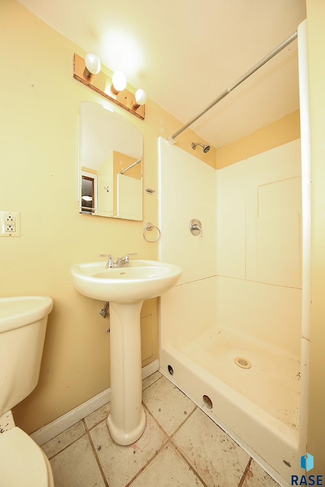 bathroom featuring tile patterned floors, a shower, and toilet