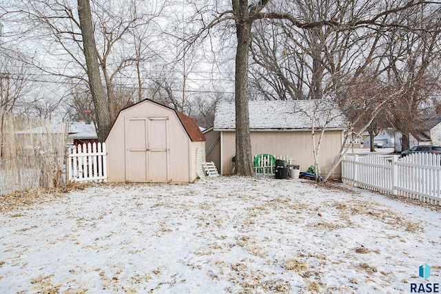 yard layered in snow featuring a storage shed