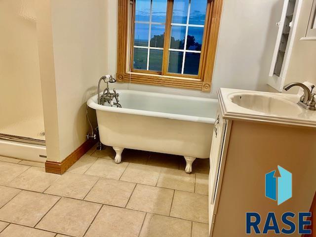 bathroom with a tub and vanity