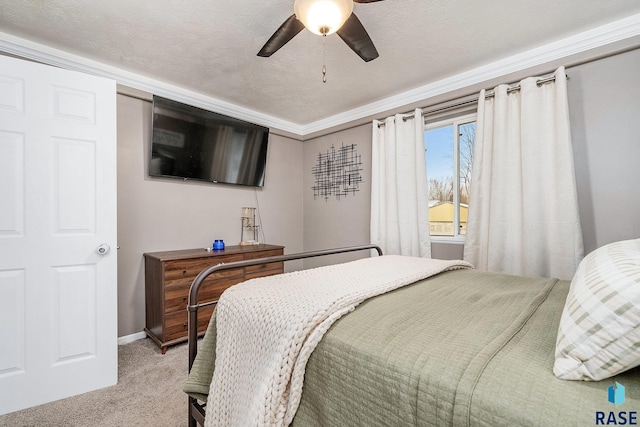 carpeted bedroom with ceiling fan, ornamental molding, and a textured ceiling