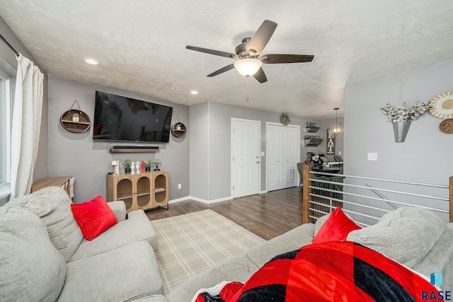 living room featuring ceiling fan, dark hardwood / wood-style flooring, and a textured ceiling