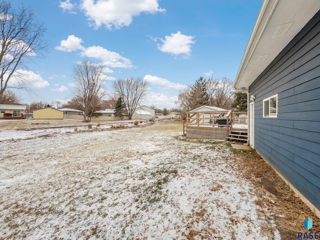 yard covered in snow with a deck