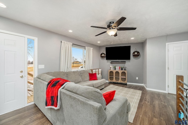 living room with ceiling fan, dark hardwood / wood-style flooring, and a textured ceiling