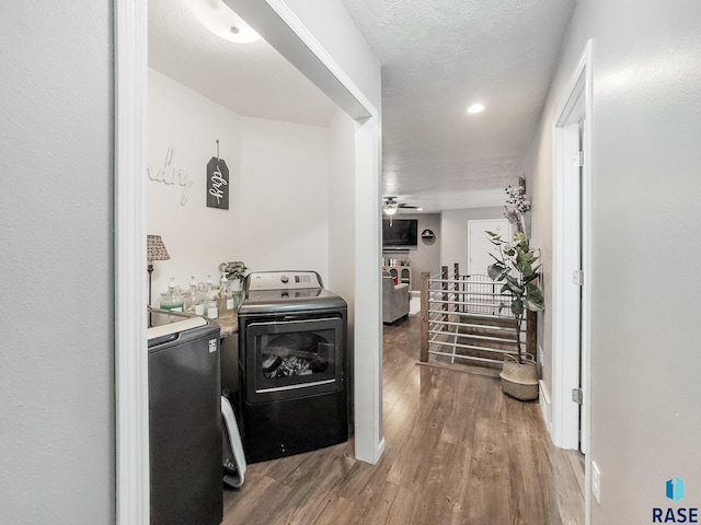 clothes washing area featuring a textured ceiling, washer / clothes dryer, hardwood / wood-style flooring, and ceiling fan