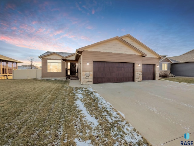 ranch-style house with a yard and a garage