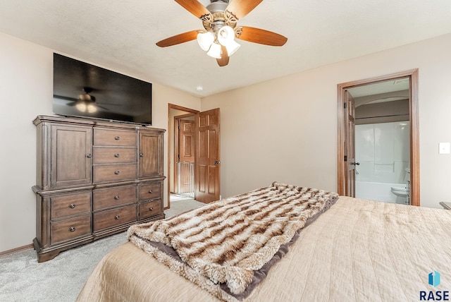 carpeted bedroom with ceiling fan and ensuite bath