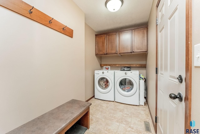 laundry area with washer and clothes dryer and cabinets