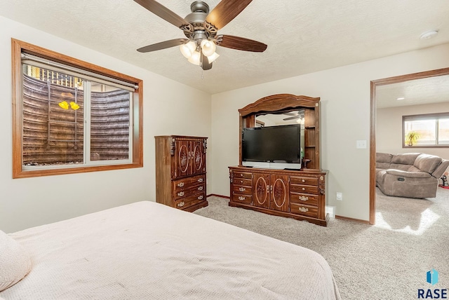 carpeted bedroom featuring a textured ceiling and ceiling fan