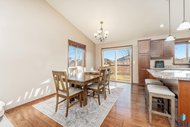 dining area featuring a chandelier, dark hardwood / wood-style flooring, and vaulted ceiling