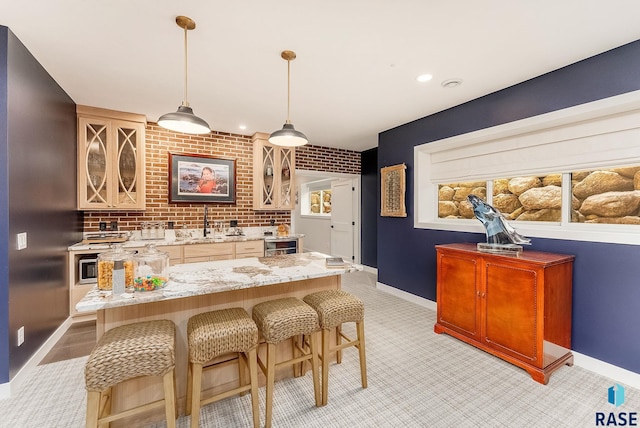 bar featuring beverage cooler, a sink, baseboards, indoor wet bar, and decorative light fixtures