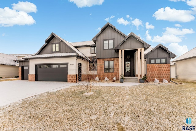 view of front of house featuring board and batten siding, brick siding, driveway, and an attached garage