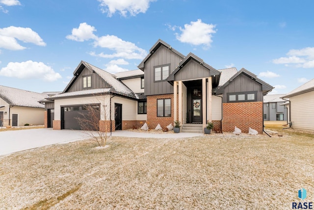 modern farmhouse style home with board and batten siding, brick siding, driveway, and a garage