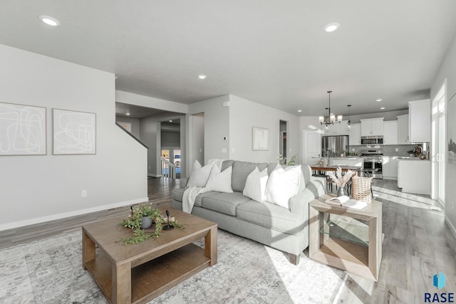 living room featuring a notable chandelier and light wood-type flooring