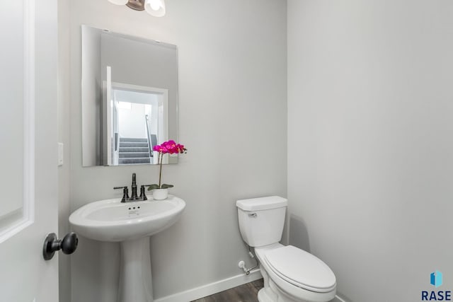 bathroom featuring wood-type flooring and toilet