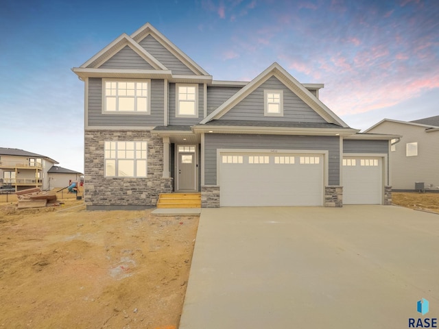 craftsman-style home featuring cooling unit and a garage