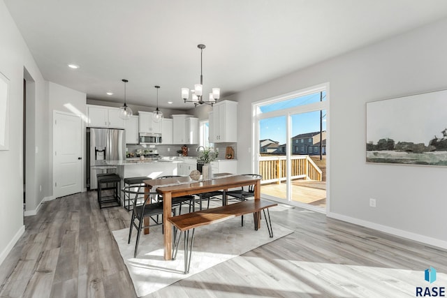 dining room with a chandelier, light hardwood / wood-style flooring, and sink