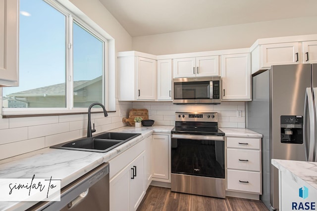 kitchen featuring appliances with stainless steel finishes, white cabinetry, decorative backsplash, sink, and dark hardwood / wood-style floors