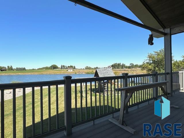 wooden terrace with a yard and a water view