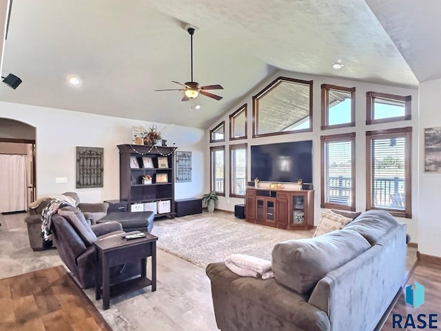 living room with ceiling fan, high vaulted ceiling, and light hardwood / wood-style floors