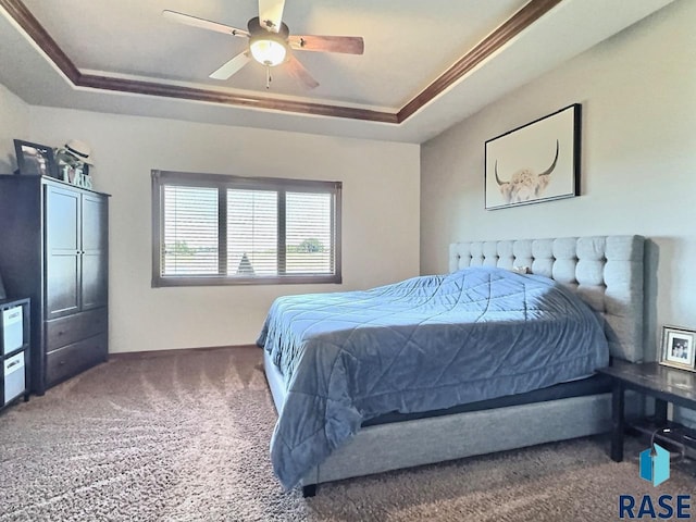 carpeted bedroom with ceiling fan and a tray ceiling