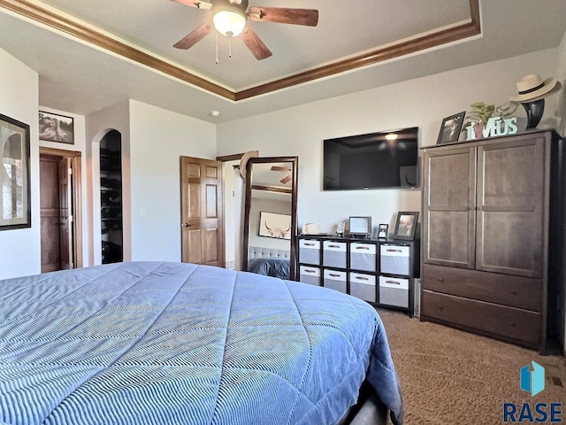 bedroom with carpet, a raised ceiling, ceiling fan, and ornamental molding