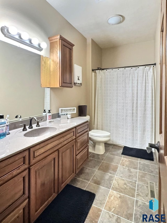 bathroom with a shower with shower curtain, vanity, and toilet