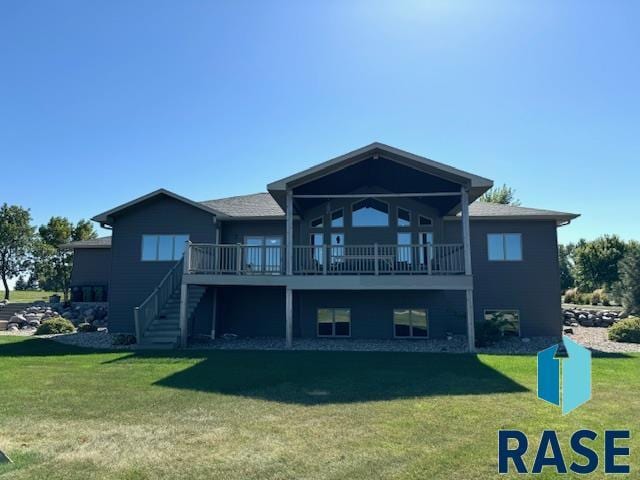 back of property with a wooden deck and a yard