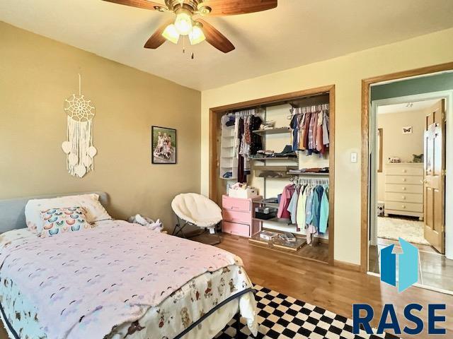 bedroom with ceiling fan, a closet, and wood-type flooring