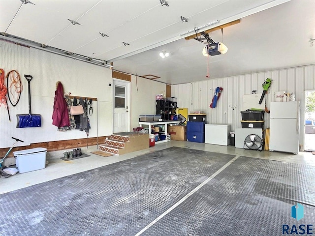 garage with white refrigerator and a garage door opener