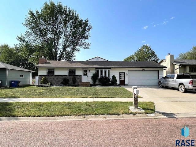 ranch-style home featuring a garage and a front lawn