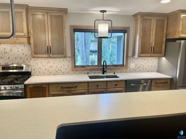 kitchen with pendant lighting, tasteful backsplash, sink, and stainless steel appliances