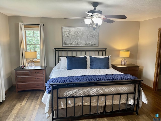 bedroom featuring ceiling fan, dark hardwood / wood-style floors, and a textured ceiling