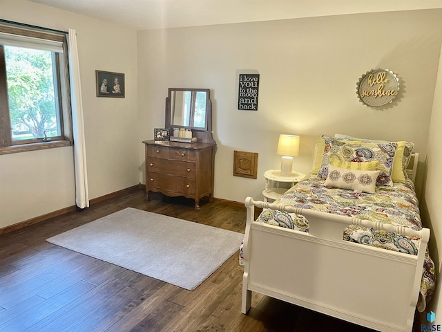 bedroom with dark hardwood / wood-style floors