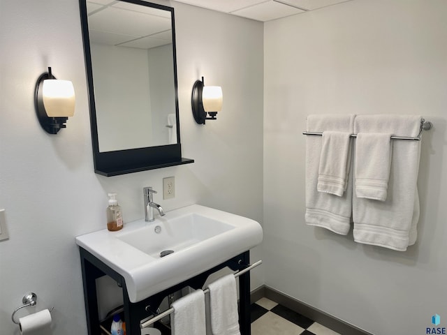 bathroom with a drop ceiling and sink